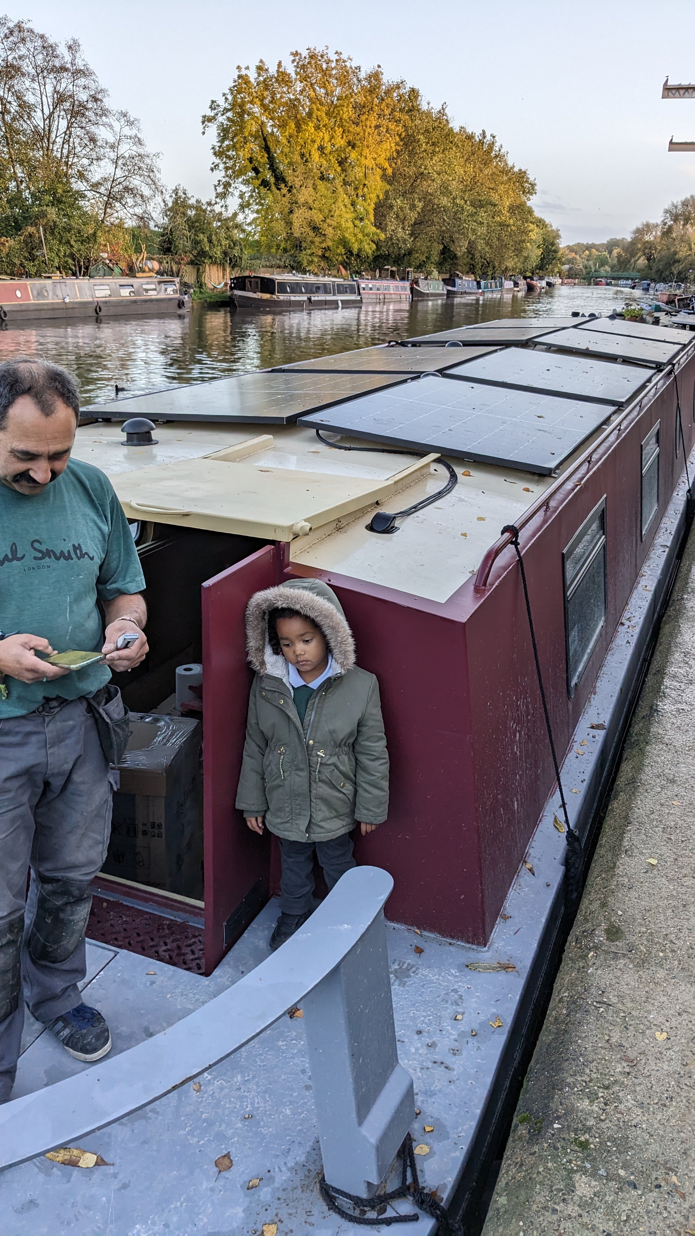 Narrowboat on canal in autumn with solar panels